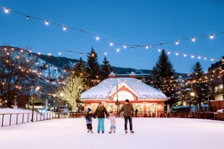 Family ice skating the Silver Circle Ice Rink downtown Aspen in the evening