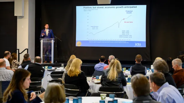 speaker at business outlook forum presenting trends of CO economic forecast