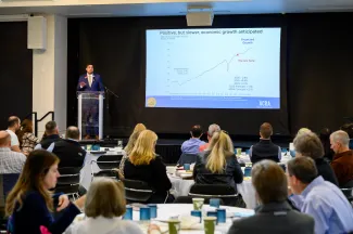 speaker at business outlook forum presenting trends of CO economic forecast
